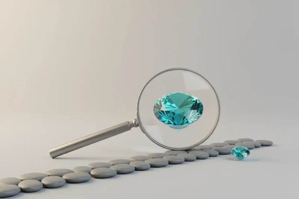 Magnifying glass reveals a vivid gemstone just off a line of gray stones, symbolizing talent found in unconventional places.